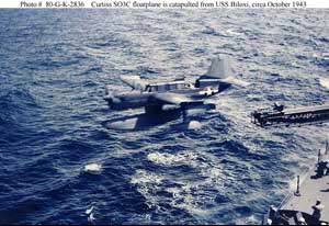 Left side view of a Curtiss SO3C Seamew catapulting off of a USN vessel; color