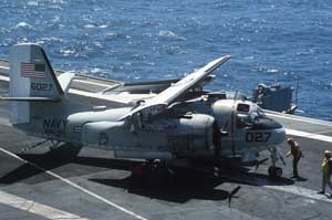 High-angled right side view of a Grumman C-1 Trader on deck; note folded wings; color