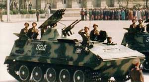 A rare view of the VTT-323 armored personnel carrier on parade; note rocket launching rack at turret rear and dual machine gun armament; color