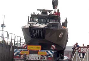 Front view of the Combat Boat 90 being loaded onto a transport trailer