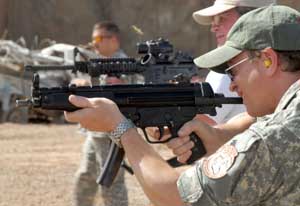Actor Gary Sinise takes aim with his HK MP5 submachine gun; note tubular stock