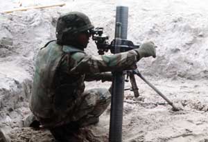 A soldier adjusts his M29 81mm mortar