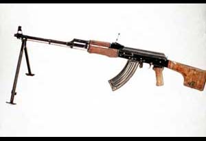 A propaganda view showcasing the left-side view of a Soviet RPK-74 light machine gun; note bipod attachment, solid stock and curved magazine