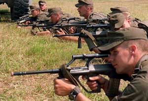 A group of soldiers practice firing their Steyr AUG assault rifles